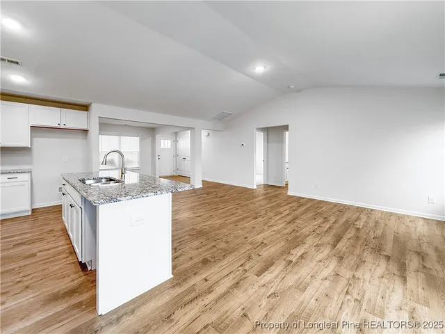 a kitchen with granite countertop a sink and a stove top oven