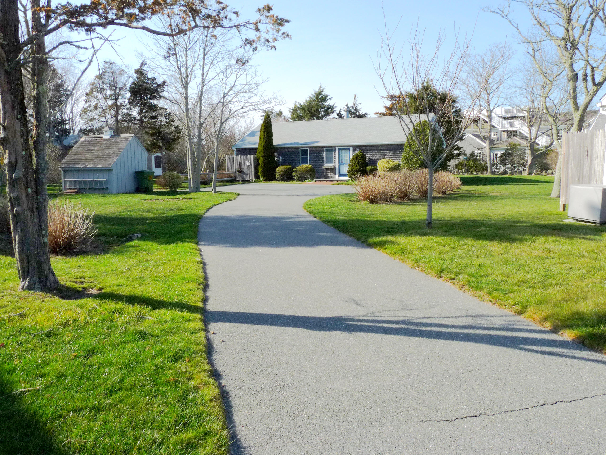 170 Beach Road, Unit 10 Orleans, MA 02653 - Photo 2 of 23 a view of a white house with a yard and plants