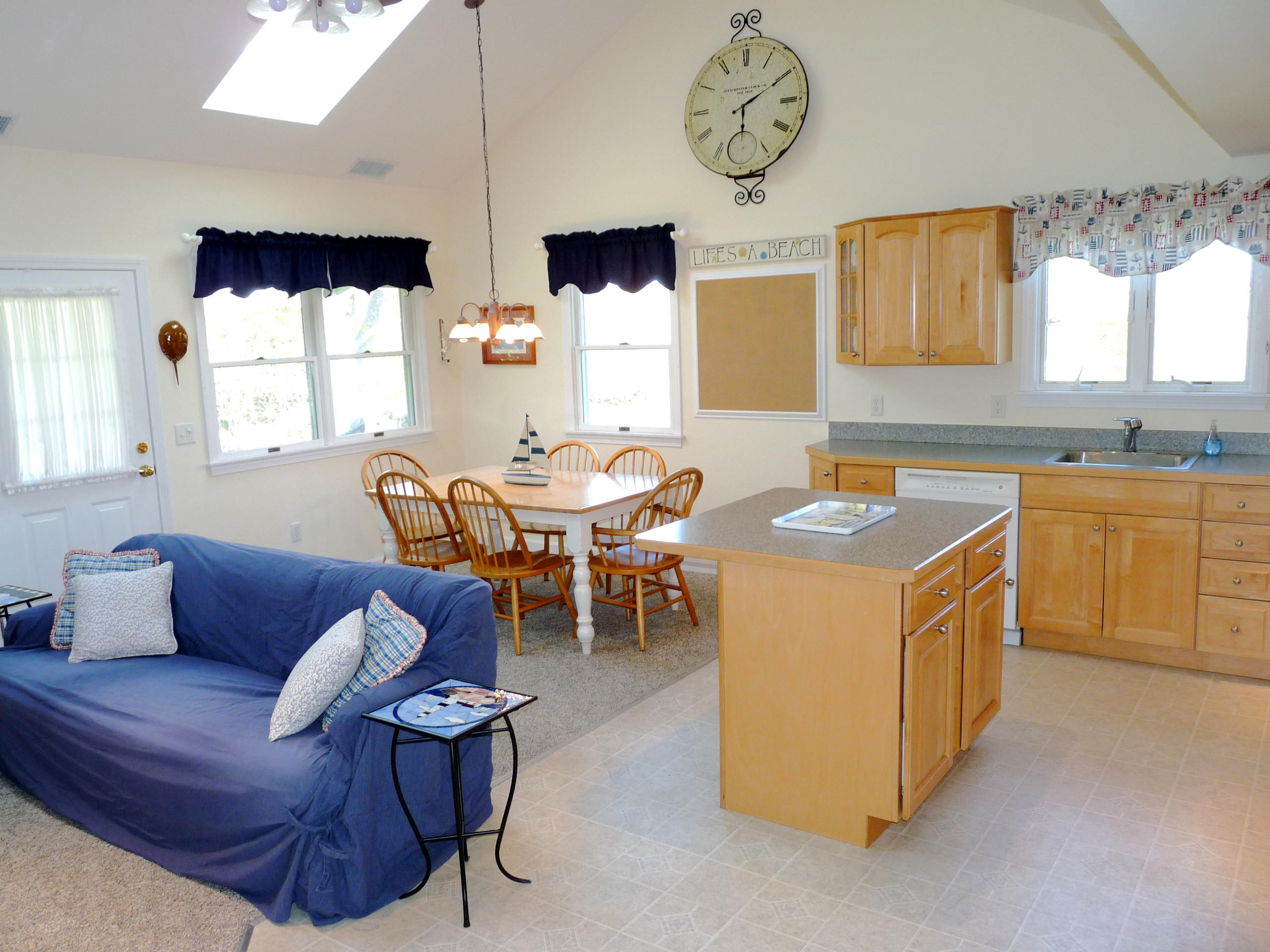 170 Beach Road, Unit 10 Orleans, MA 02653 - Photo 8 of 23 a kitchen with stainless steel appliances granite countertop a sink a stove a dining table and chairs with wooden floor