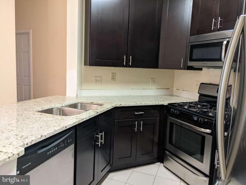a kitchen with granite countertop stainless steel appliances a sink dishwasher stove and oven with wooden floor