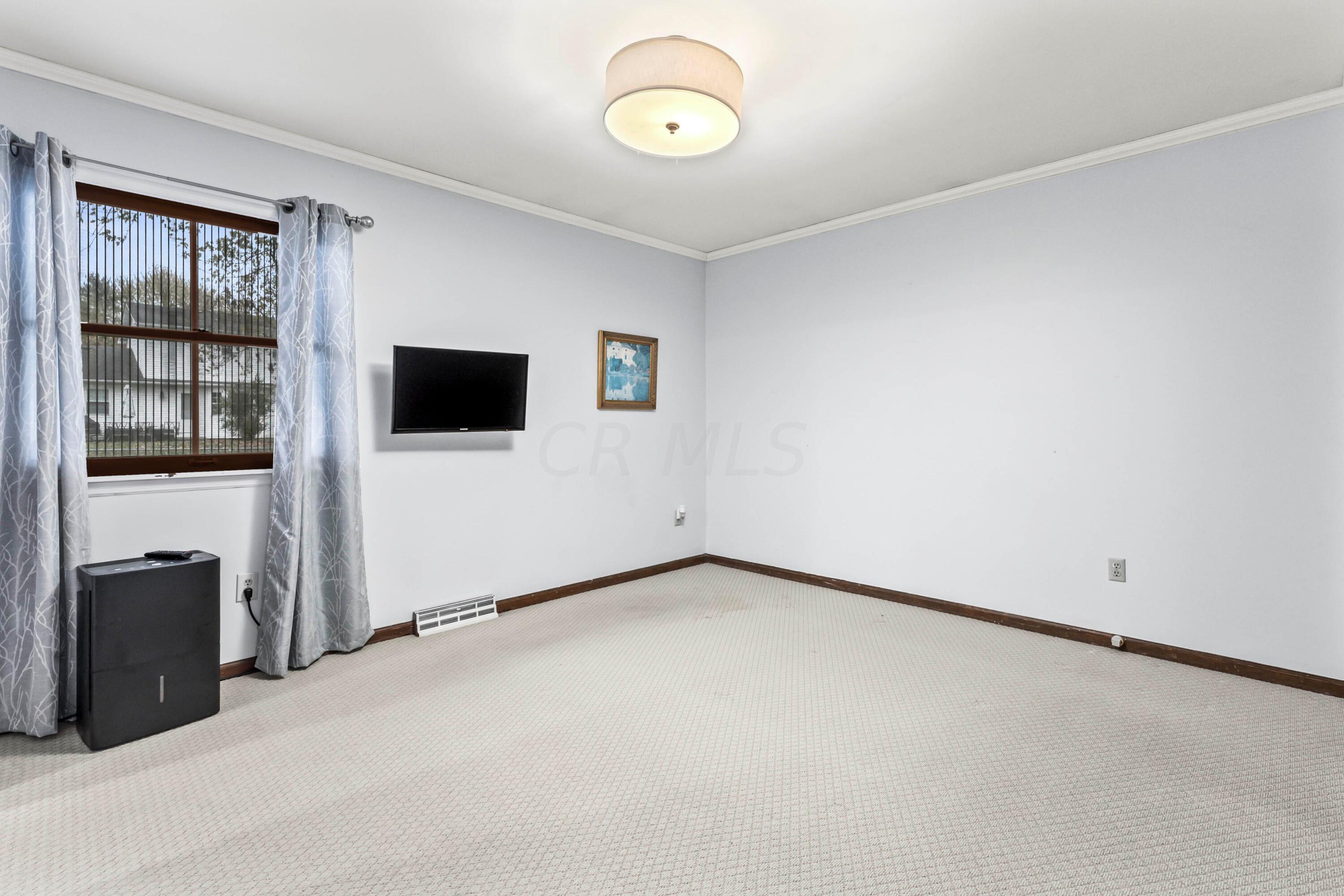 7020 Rieber Street Columbus, OH 43085 - Photo 25 of 40 • Berber carpet • Grey painted walls • New ceiling light ~ 2017 • Crown molding • Two lighted closets with double sliding doors • TV & mount are negotiable