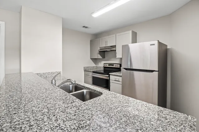 a kitchen with a refrigerator sink and stove