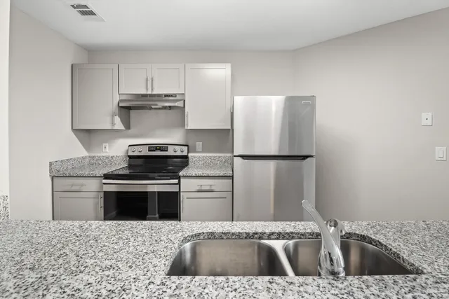 a kitchen with a sink stove and refrigerator