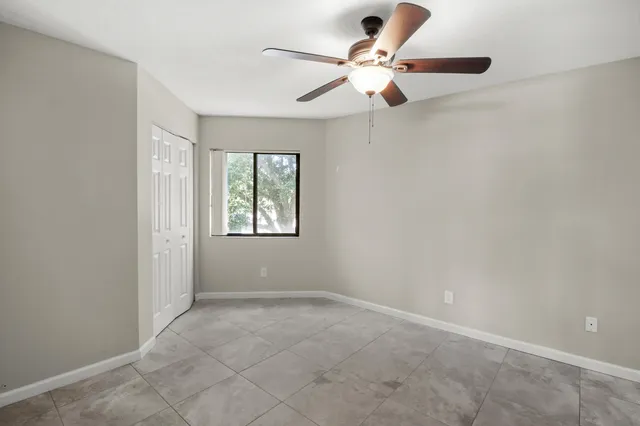 an empty room with a window and a fan