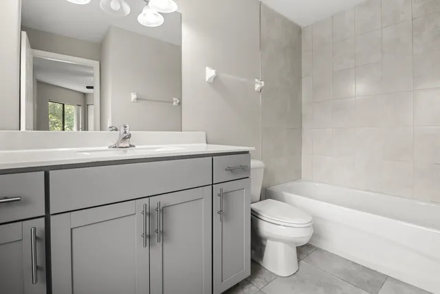 a bathroom with a sink toilet vanity and bathtub