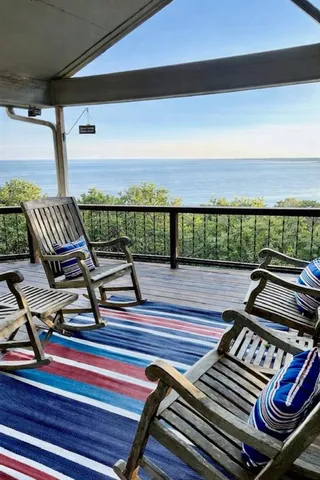 a view of a balcony with wooden floor outdoor seating and city view