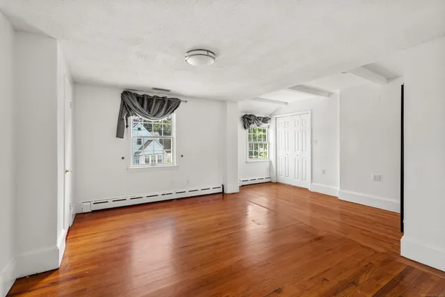 an empty room with wooden floor and window