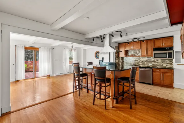 a kitchen with stainless steel appliances granite countertop wooden floors stove and cabinets