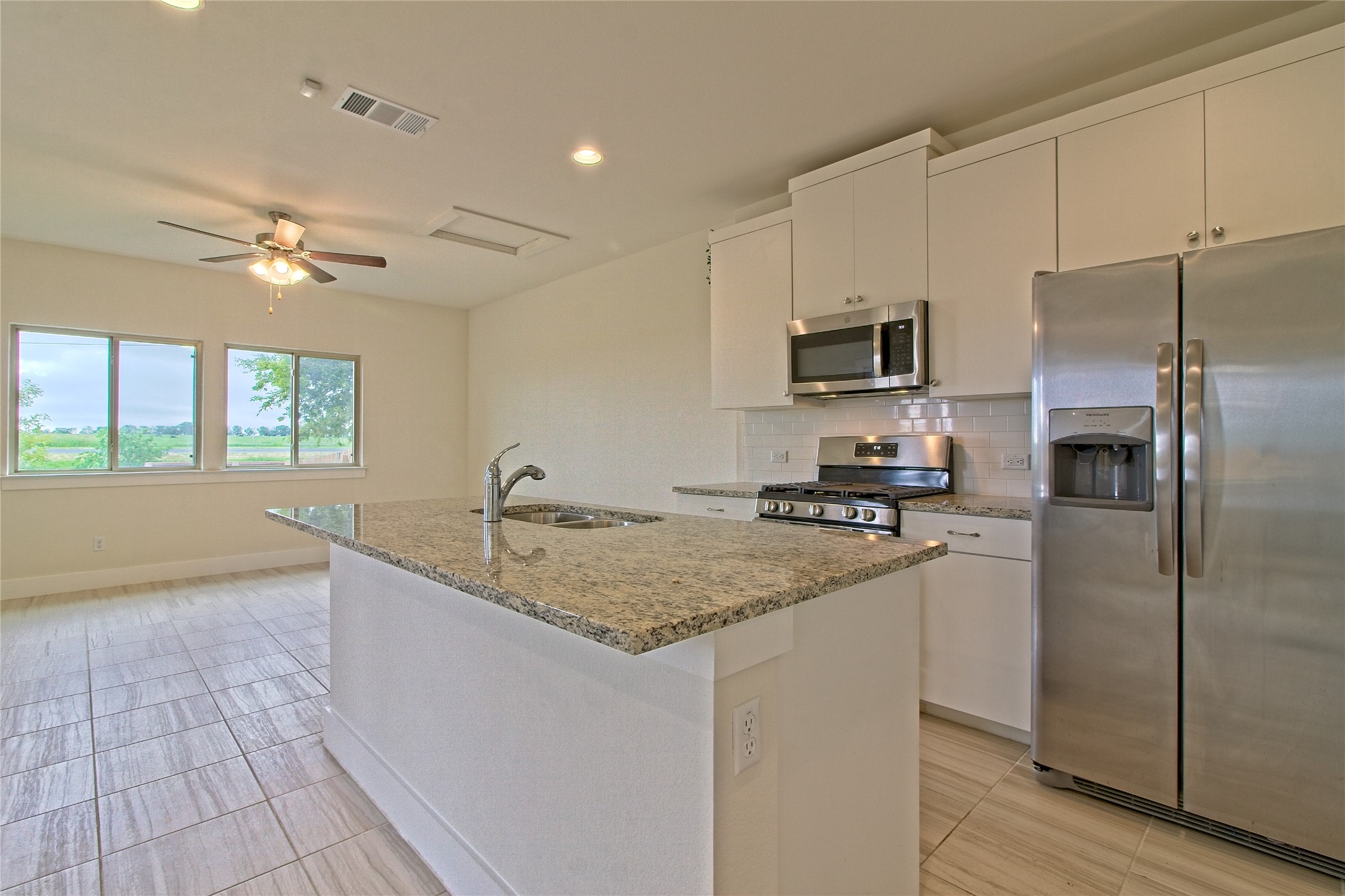 555 White Steppe Way Georgetown, TX 78626 - Photo 12 of 40 a kitchen with stainless steel appliances granite countertop a sink stove and refrigerator