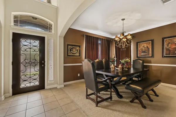 a view of a dining room with furniture and chandelier