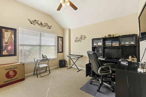 a view of a workspace with furniture and a window