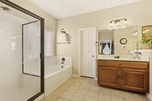a bathroom with a tub sink and mirror