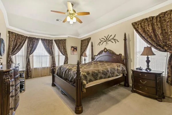 a spacious bedroom with a bed and a chandelier