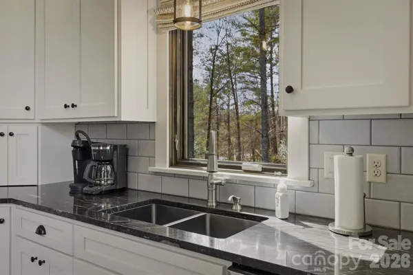 a kitchen with granite countertop a sink stove and refrigerator