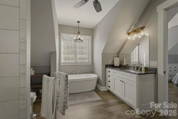 a bathroom with a granite countertop sink a toilet a mirror and shower