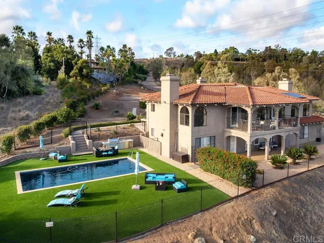 a view of a house with a yard and potted plants