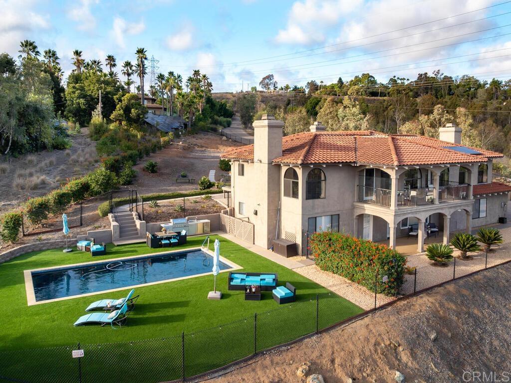 a view of a house with a yard and potted plants