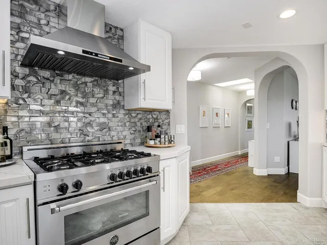 a kitchen with a stove and a white cabinets