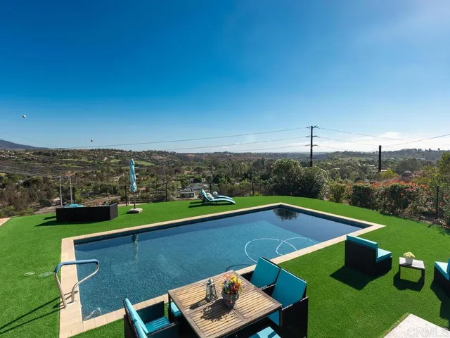 a living room with patio furniture and a floor to ceiling window