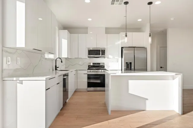 a kitchen with stainless steel appliances kitchen island granite countertop a sink and chairs
