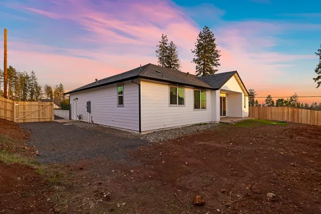 a view of a yard with wooden fence