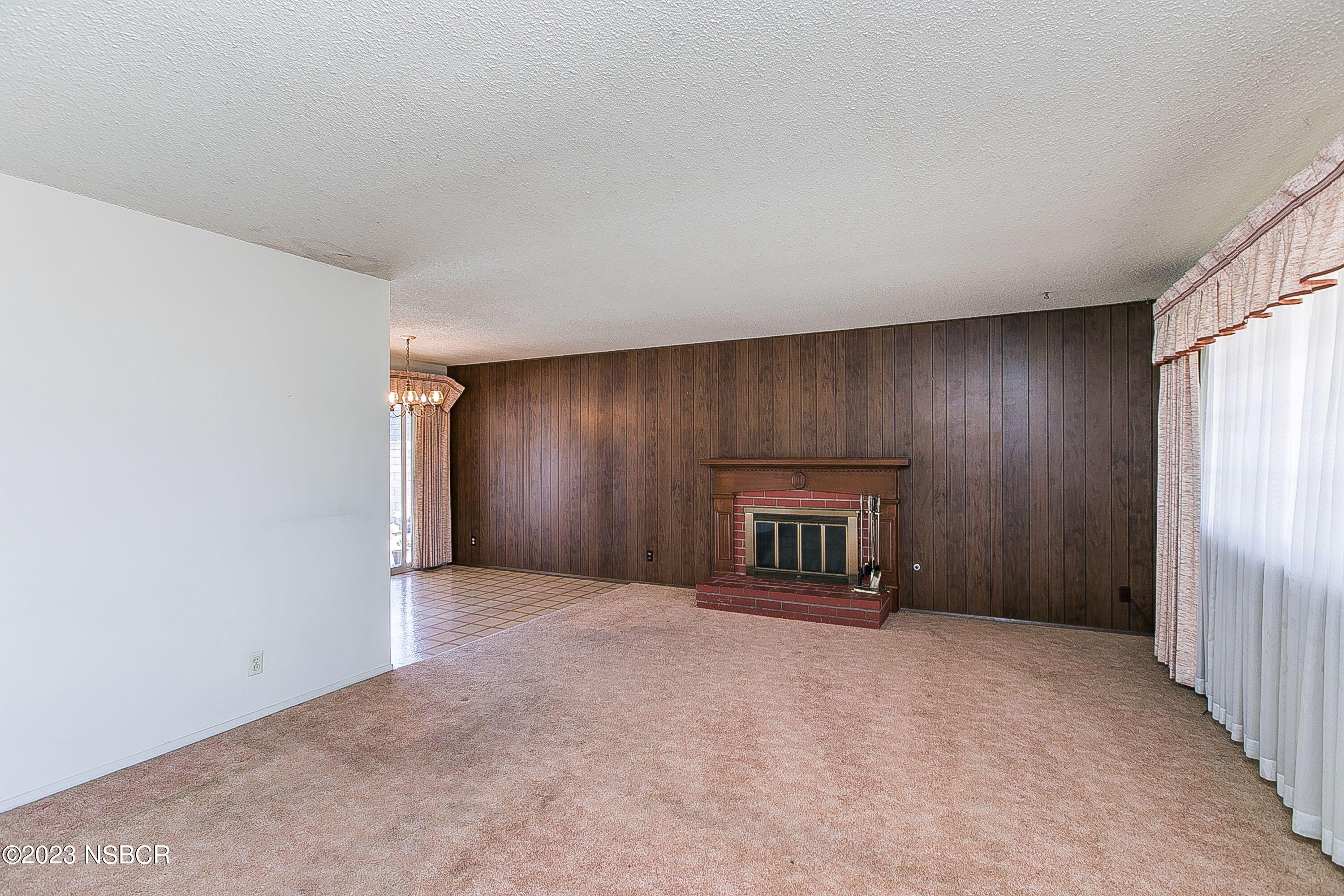 4071 Rigel Avenue Lompoc, CA 93436 - Photo 5 of 24 an empty room with a fireplace and a window