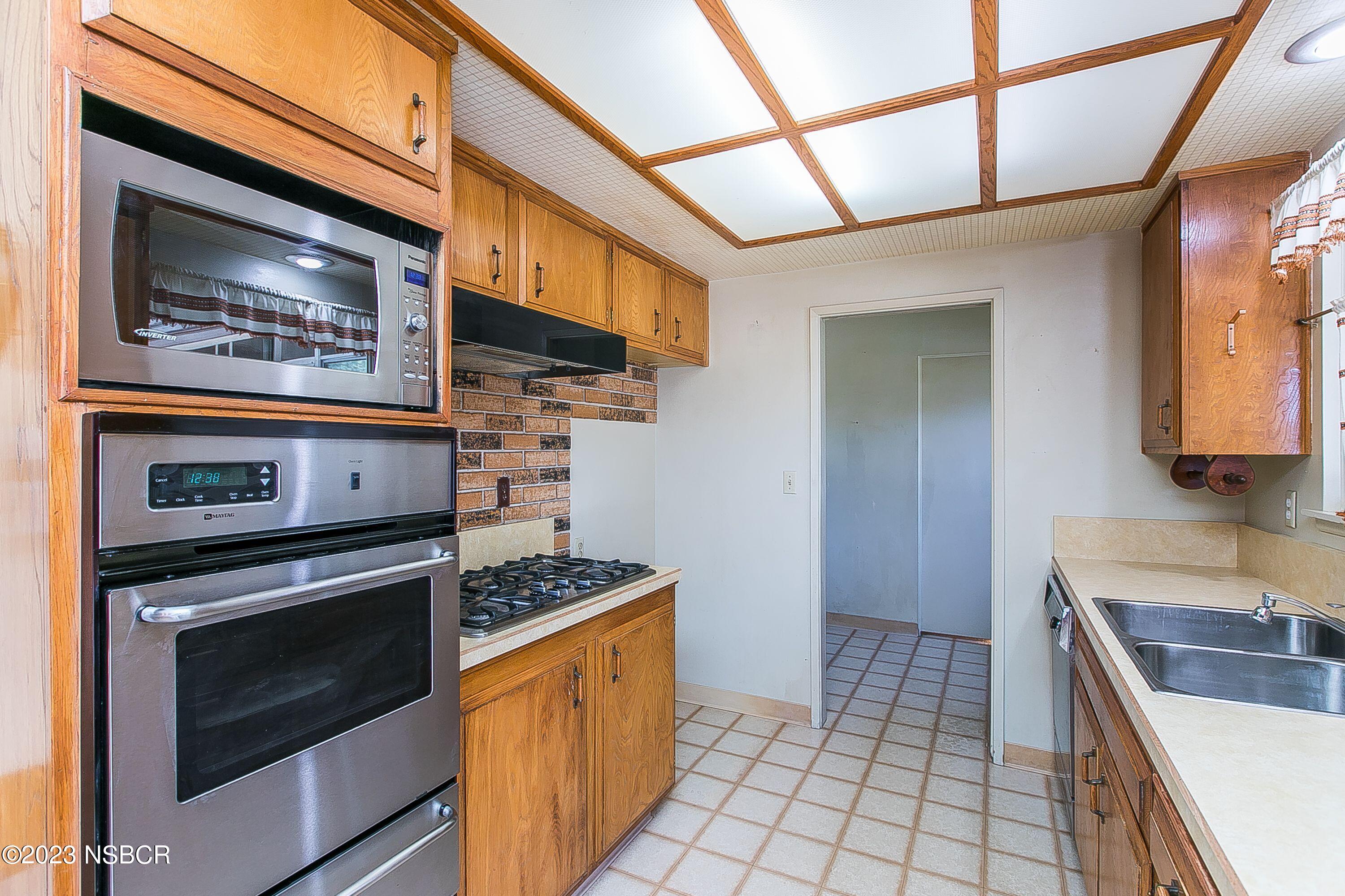 4071 Rigel Avenue Lompoc, CA 93436 - Photo 9 of 24 a kitchen with stainless steel appliances granite countertop a stove microwave and sink