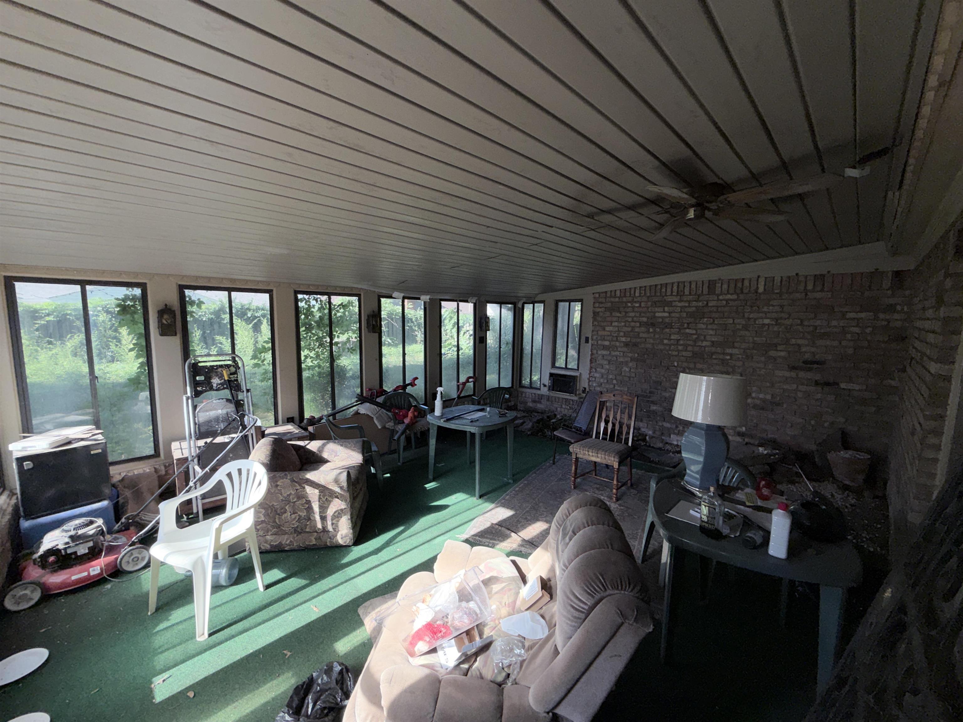 5536 Cottonwood Road Memphis, TN 38115 - Photo 11 of 28 Enclosed sunroom featuring a brick accent wall, extensive window panels, a slatted ceiling, and a ceiling fan