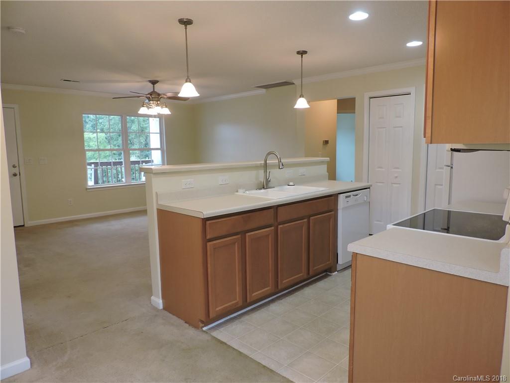 598 Lickstone Road Waynesville, NC 28786 - Photo 23 of 32 a kitchen with a sink a chandelier stainless steel appliances and a chandelier