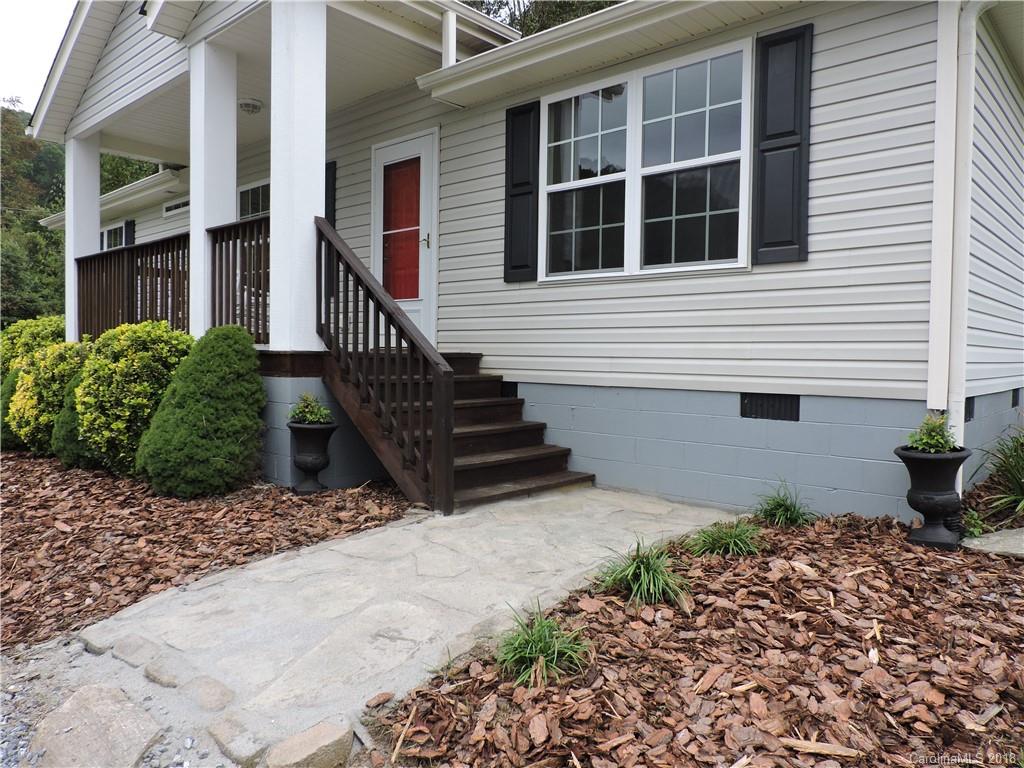 598 Lickstone Road Waynesville, NC 28786 - Photo 8 of 32 a view of a house with wooden fence and potted plants