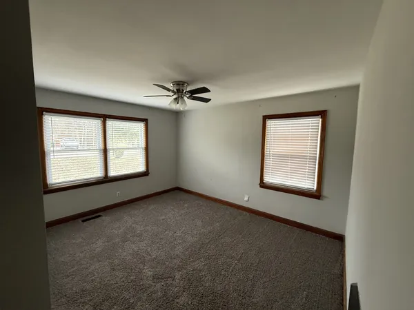 an empty room with windows and closet