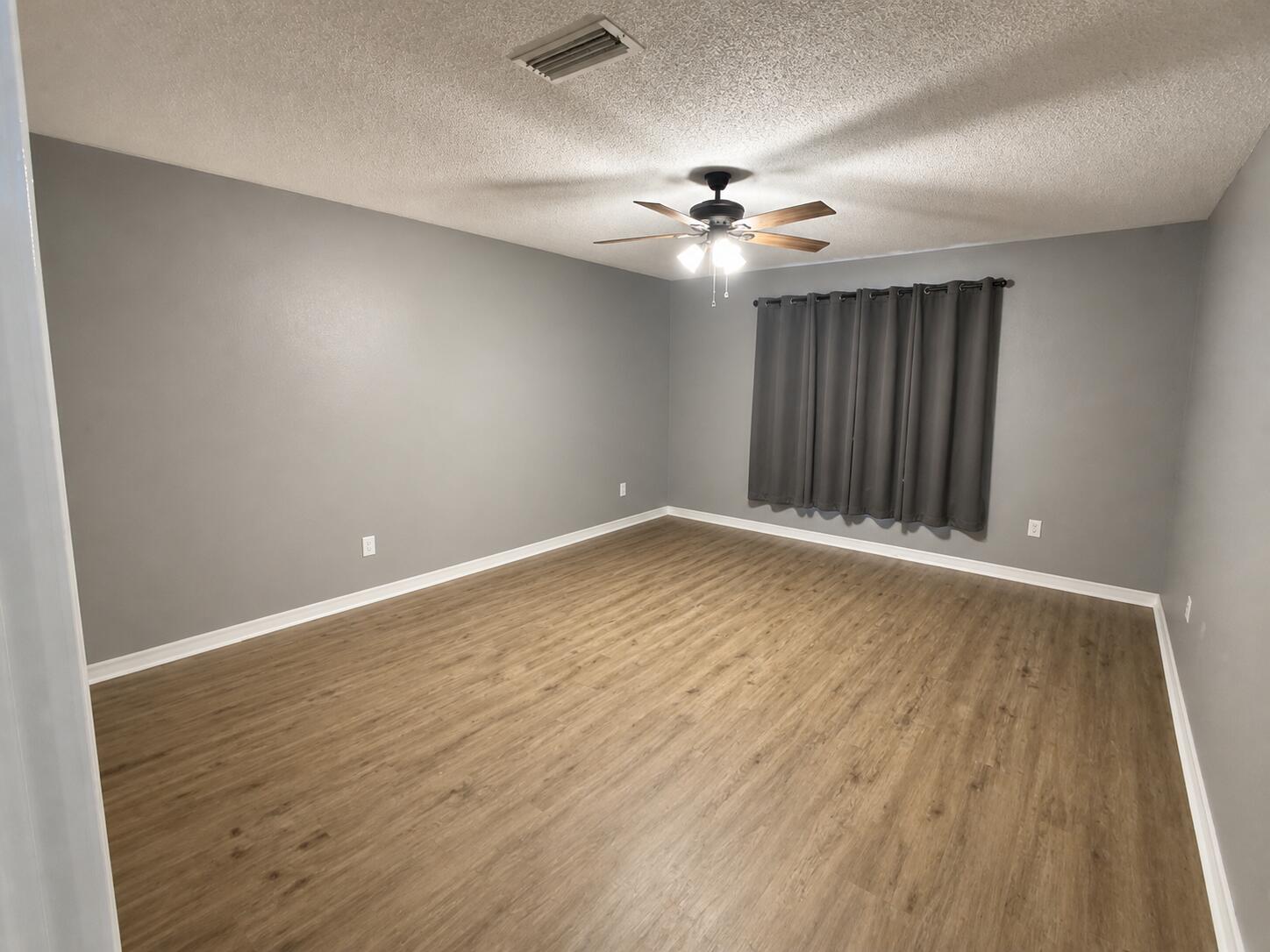 2155 Hagood Loop Crestview, FL 32536 - Photo 7 of 16 an empty room with wooden floor chandelier fan and closet area