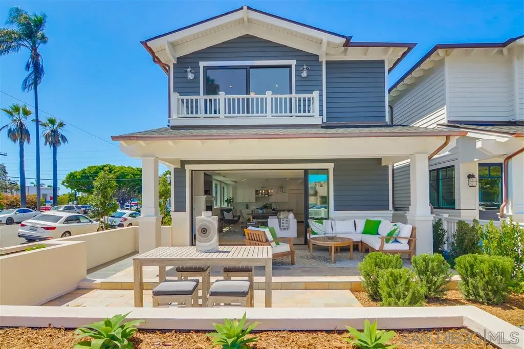 a view of a house with potted plants and a table and chairs