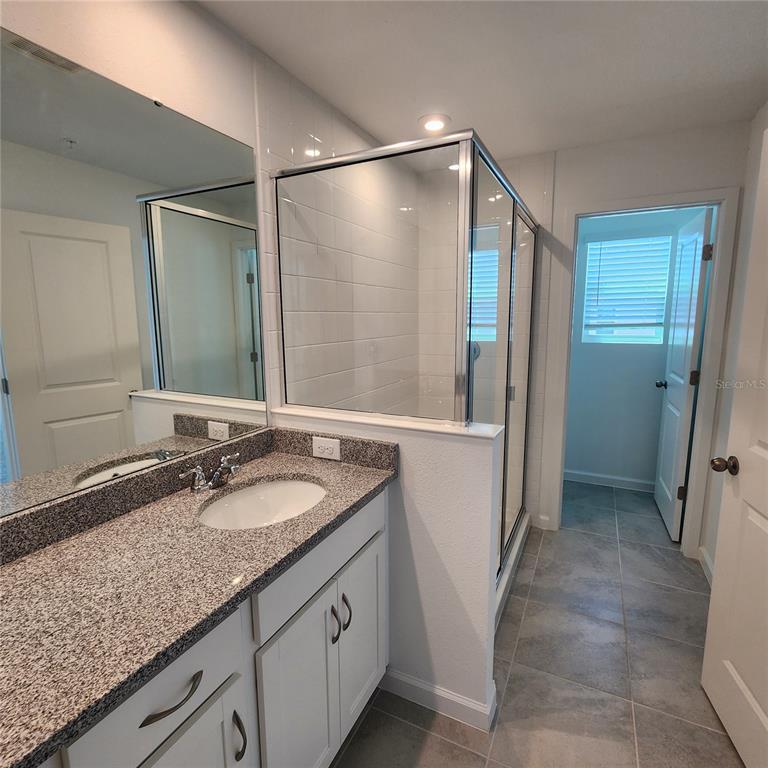 4232 Sadler Road Apopka, FL 32712 - Photo 12 of 31 a bathroom with a granite countertop sink mirror and shower