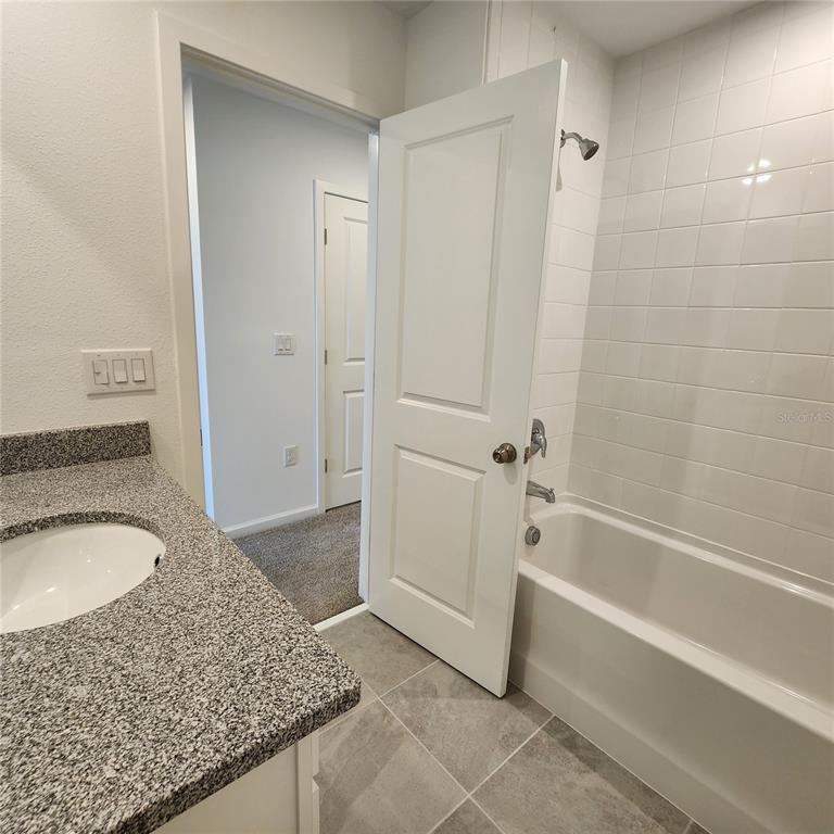 4232 Sadler Road Apopka, FL 32712 - Photo 18 of 31 a bathroom with a granite countertop sink and mirror with bathtub