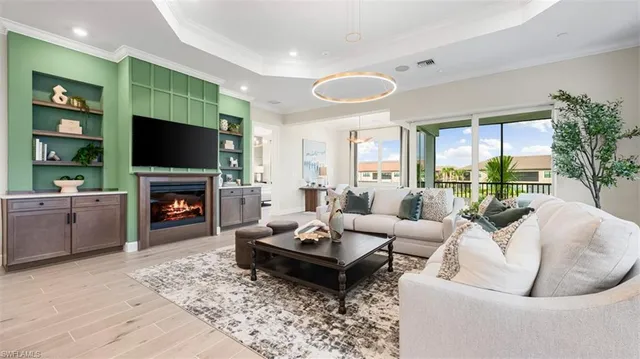 a living room with furniture a fireplace a flat screen tv and a large window