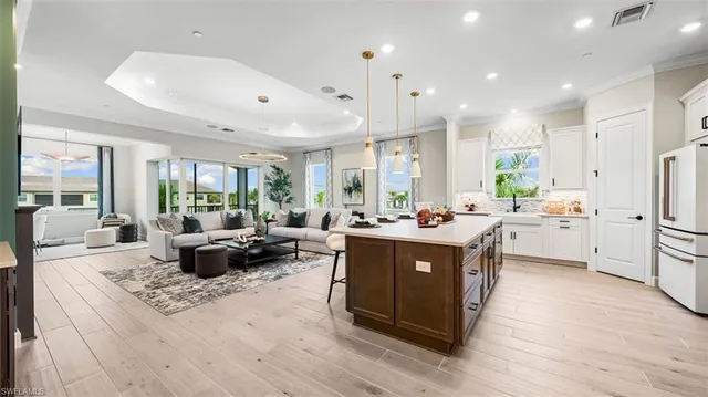 a kitchen with stainless steel appliances granite countertop a lot of white cabinets and couches