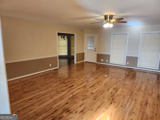 a view of an empty room with wooden floor