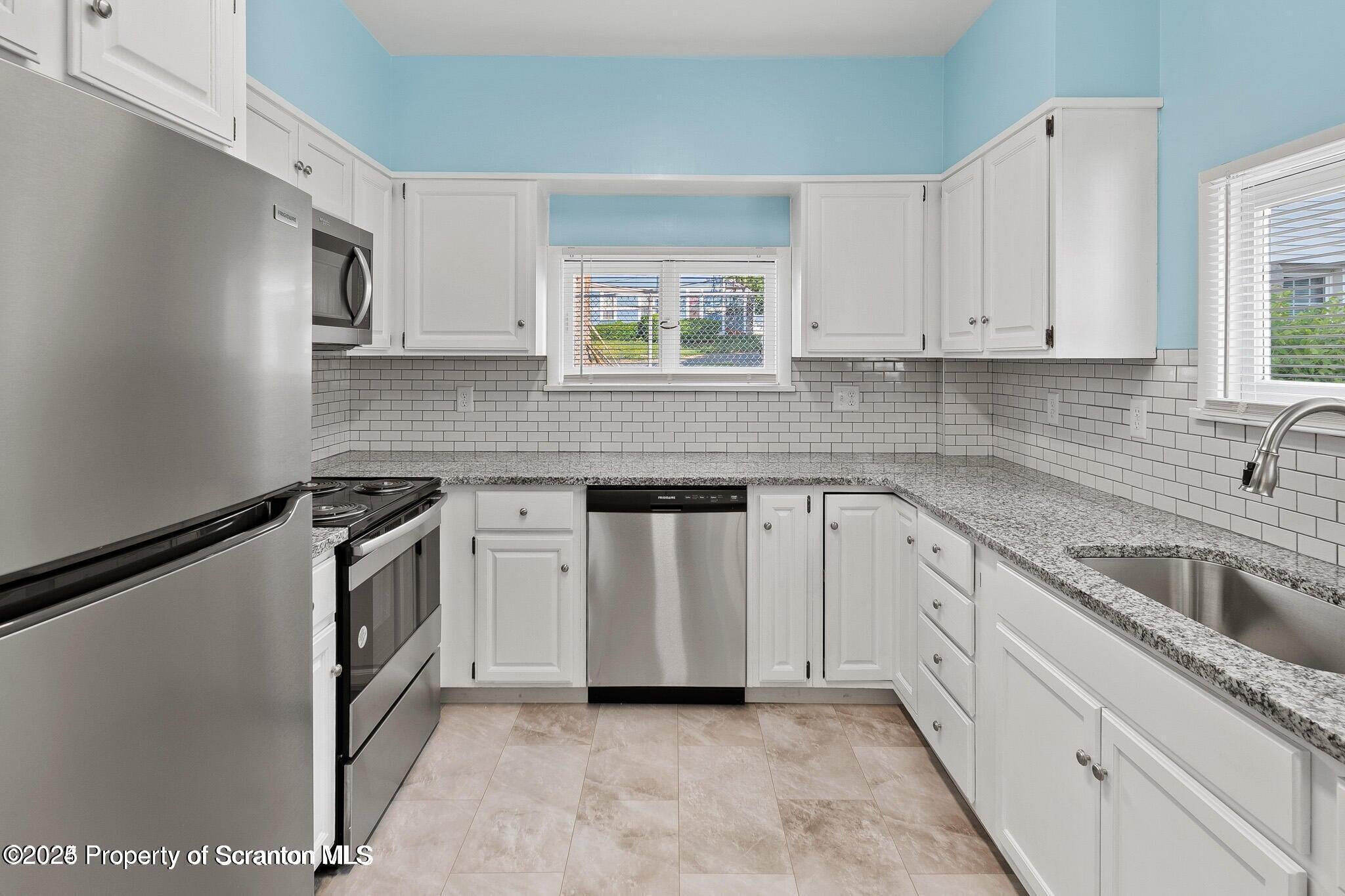 724 Electric Street Scranton, PA 18509 - Photo 7 of 17 a kitchen with white cabinets appliances and a window