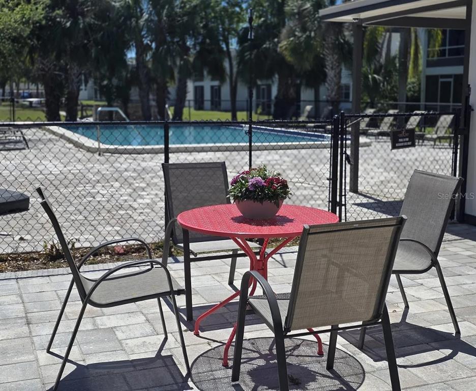 9911 Aquarius Drive, Unit 8 Port Richey, FL 34668 - Photo 19 of 25 a patio with table and chairs and potted plants