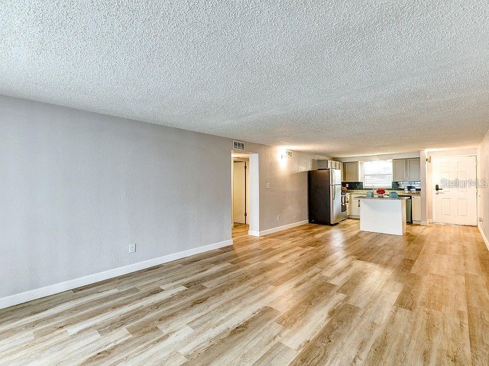 9911 Aquarius Drive, Unit 8 Port Richey, FL 34668 - Photo 6 of 25 a view of a kitchen with granite countertop cabinets and refrigerator