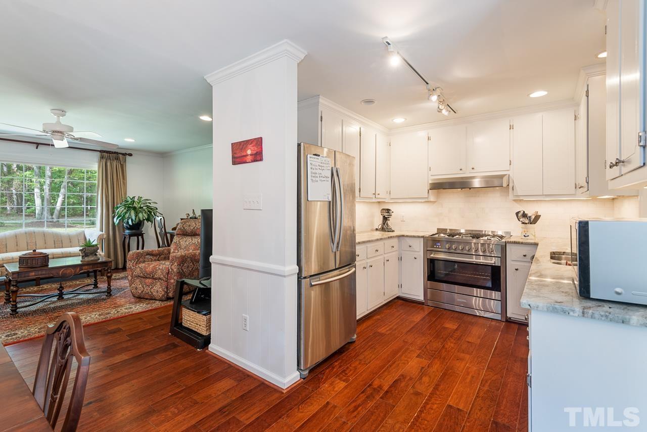 7612 Jock Road Bahama, NC 27503 - Photo 18 of 53 a kitchen with a refrigerator cabinets and wooden floors