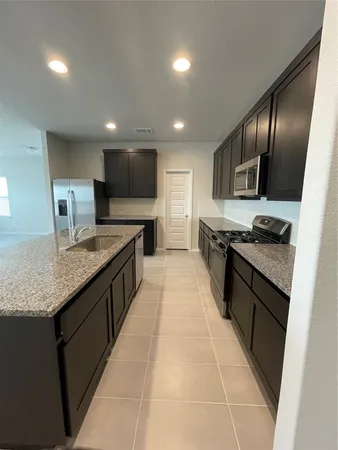 a large kitchen with granite countertop stainless steel appliances and a sink