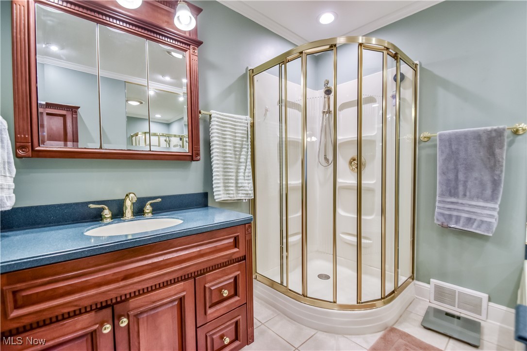 9715 Johnnycake Ridge Road Mentor, OH 44060 - Photo 14 of 50 Full bathroom featuring a stall shower, vanity, tile patterned flooring, and crown molding