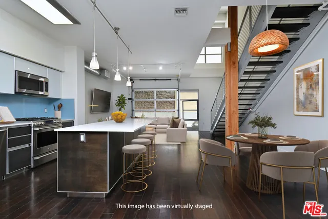a kitchen with stainless steel appliances granite countertop a stove and a dining table