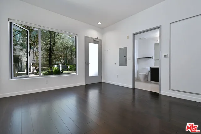 a view of a livingroom with wooden floor and a large window