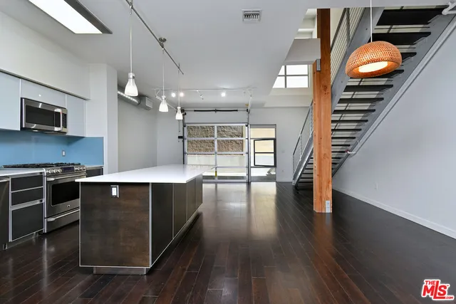 a kitchen with stainless steel appliances granite countertop a stove and a wooden floors