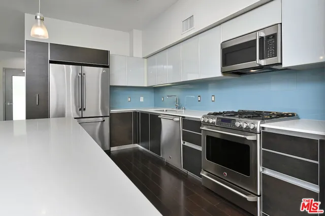 a kitchen with stainless steel appliances a stove microwave and a sink