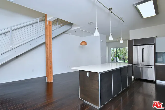 a kitchen with a sink a refrigerator and wooden floor