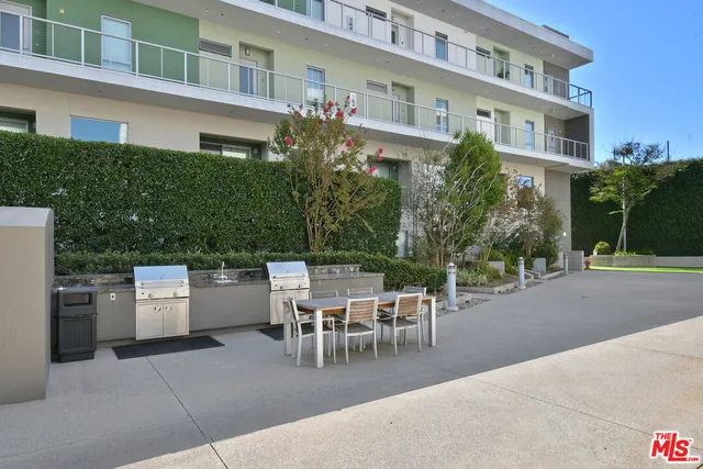 a patio with a table and chairs and potted plants